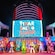 Pixar Characters waving on the deck of a Disney cruise ship with a screen that reads ‘Pixar Pals Celebration’